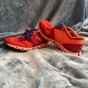 On Running Red and Orange Athletic Shoes for Trail Adventures